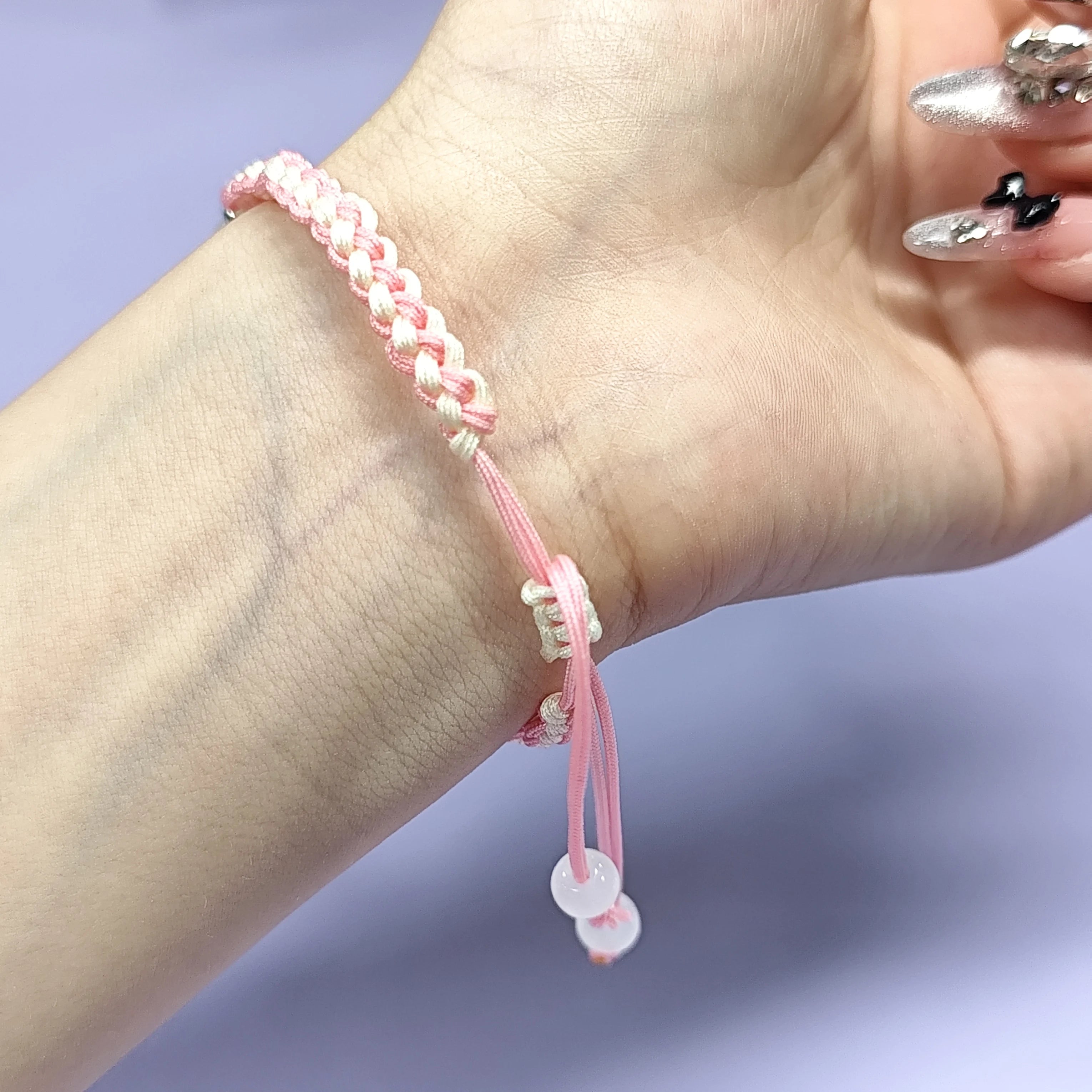 Hand - braided bracelet with a pink bear charm, beads, and a silver pendant. Cute and delicate accessory.