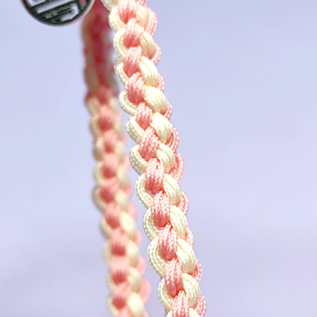 Hand - braided bracelet with a pink bear charm, beads, and a silver pendant. Cute and delicate accessory.