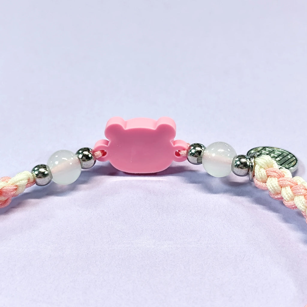 Hand - braided bracelet with a pink bear charm, beads, and a silver pendant. Cute and delicate accessory.