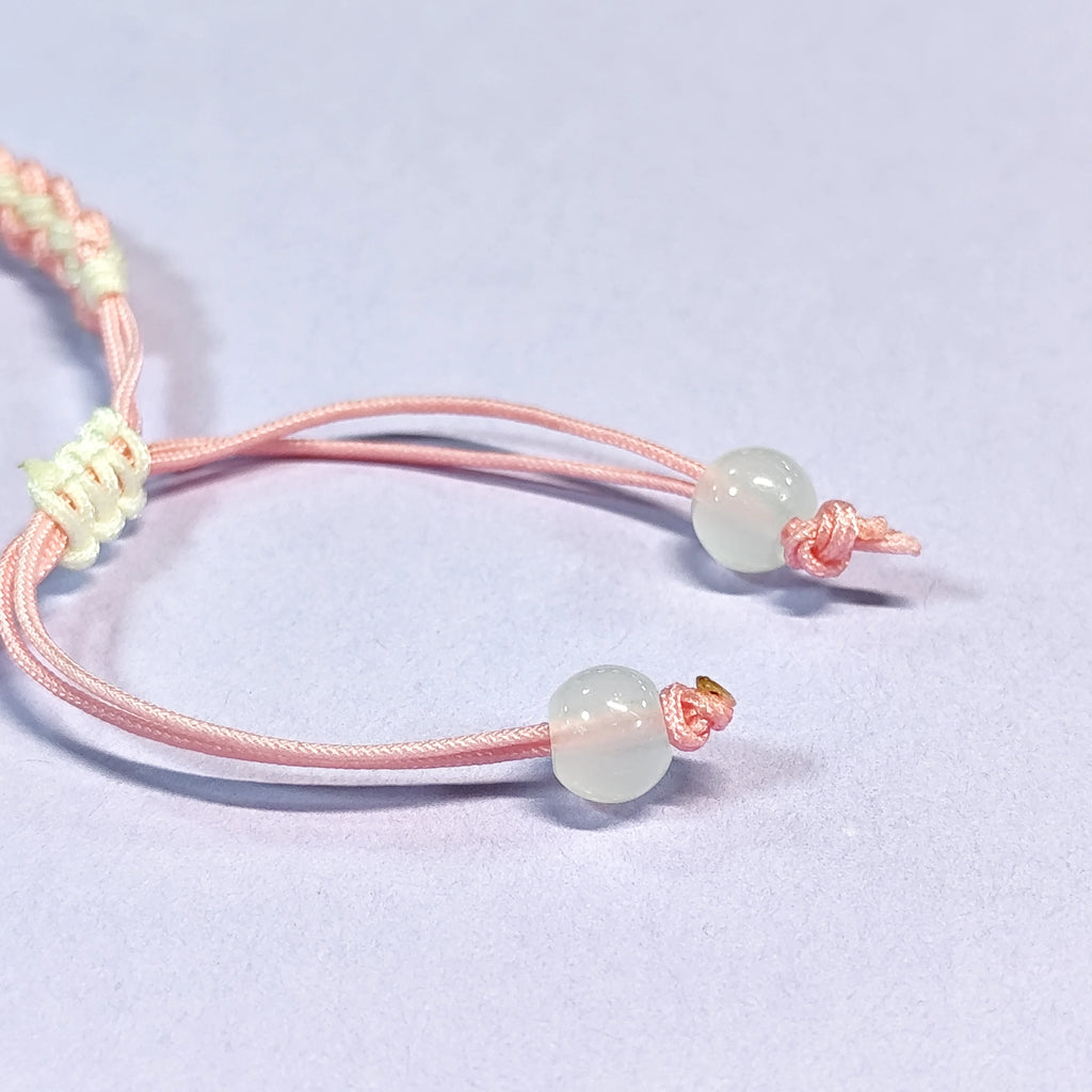 Hand - braided bracelet with a pink bear charm, beads, and a silver pendant. Cute and delicate accessory.